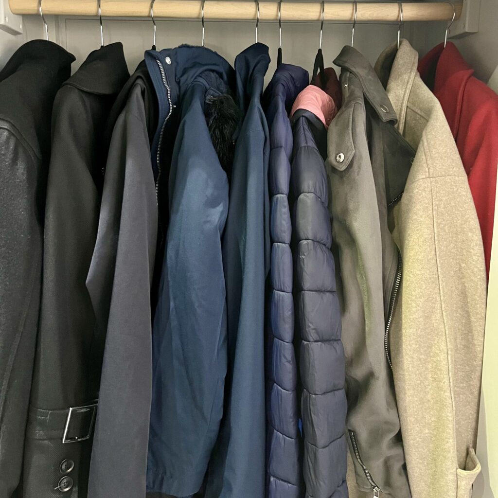 Organised coat cupboard with shelves, hooks, and entryway storage