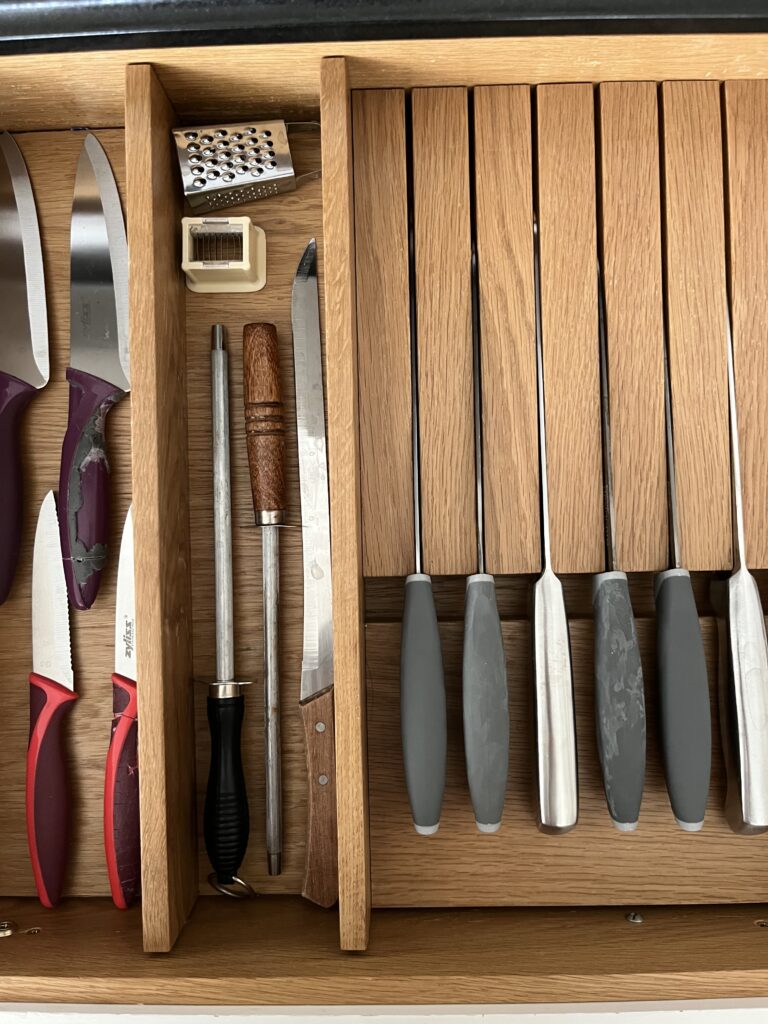Organised kitchen drawers with dividers and utensils for efficient storage