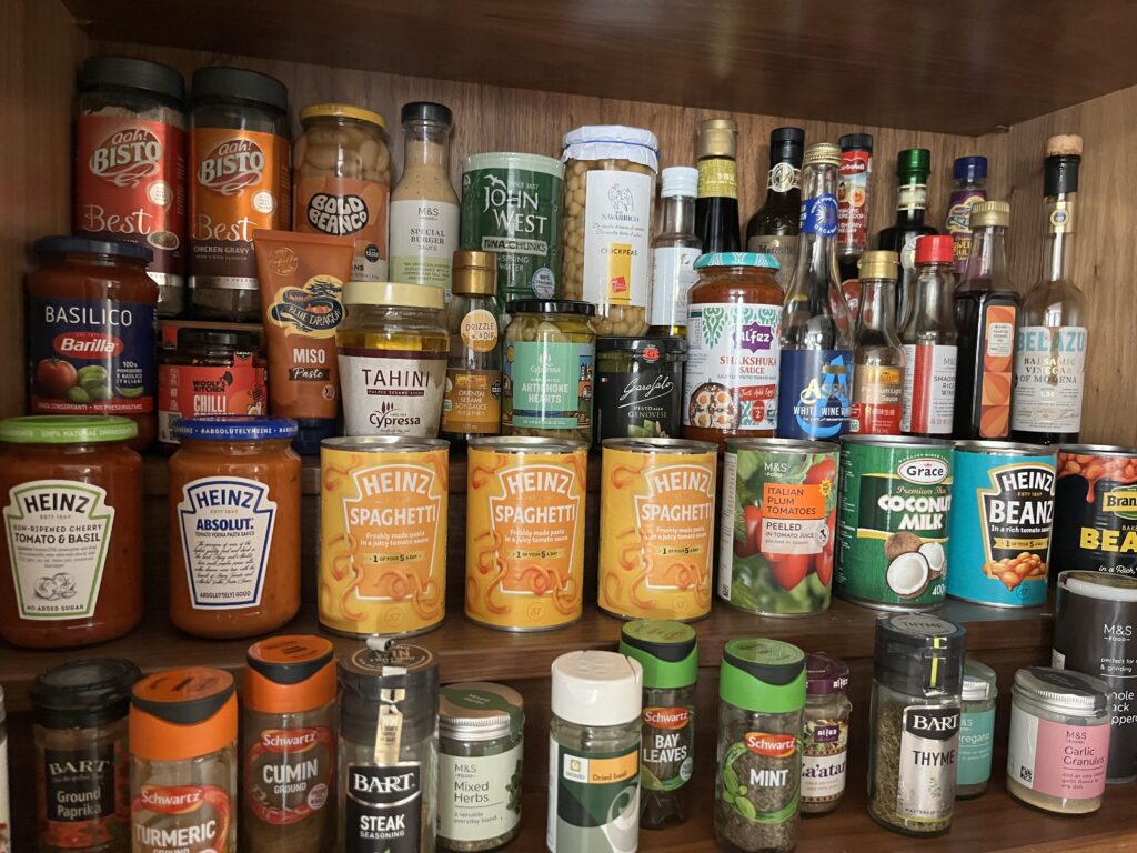 Organised pantry shelves with labeled clear containers and jars