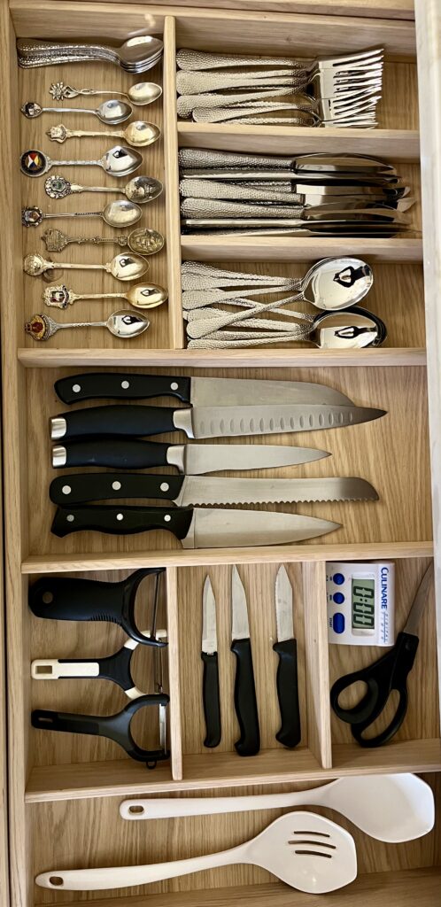 Organised kitchen drawers with dividers and utensils for efficient storage